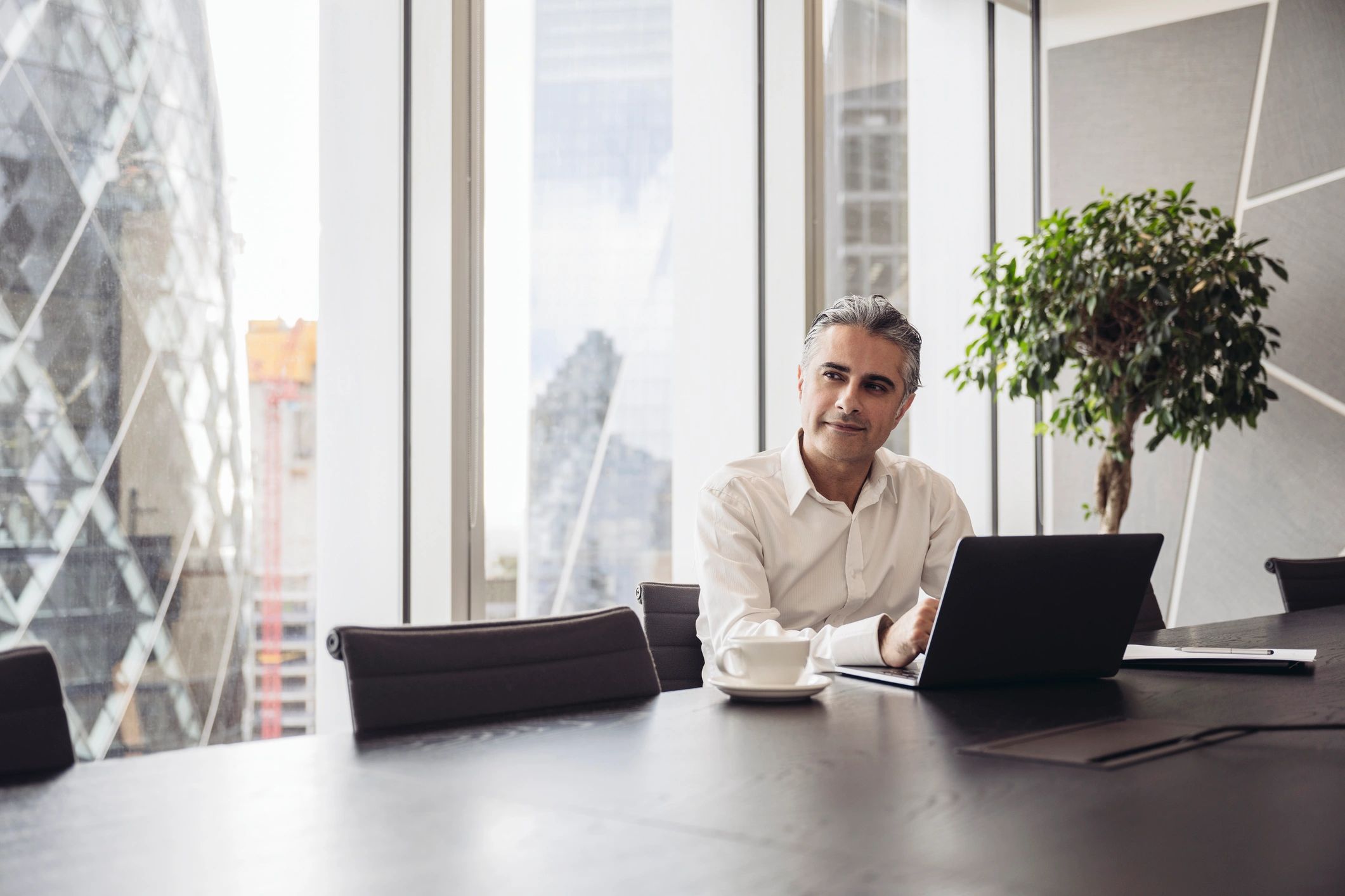 Technology consultant working on a laptop in a modern meeting room